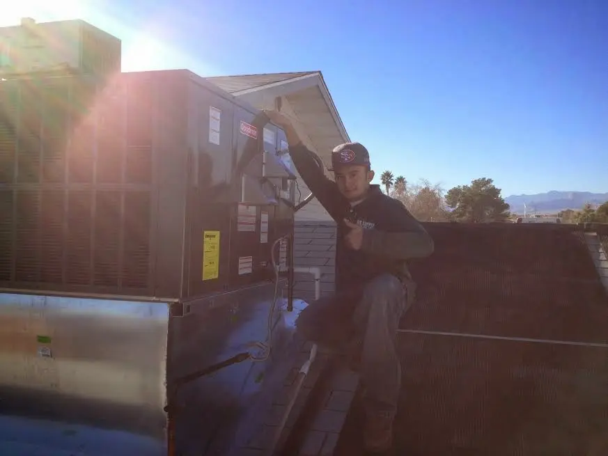 HVAC technician performing Heat Pump Repair on a rooftop unit in Waconia